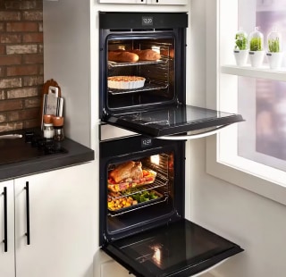 A black double oven set in white cabinetry