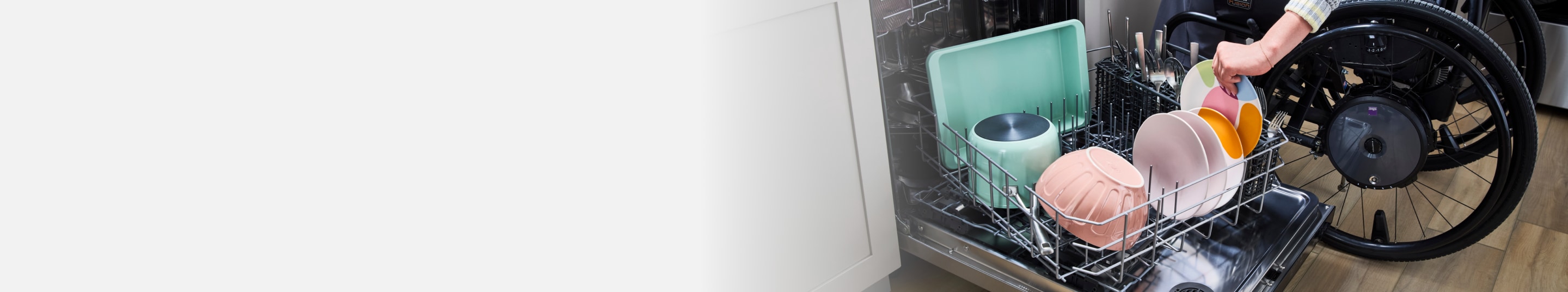 A person unloading dishes from the Spin&Load Rack