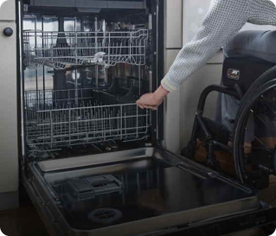 A person rolling the Spin&Load Rack back into the dishwasher
