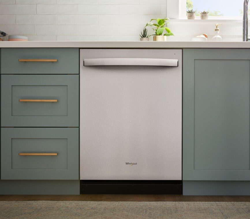 A Whirlpool dishwasher installed with green cabients