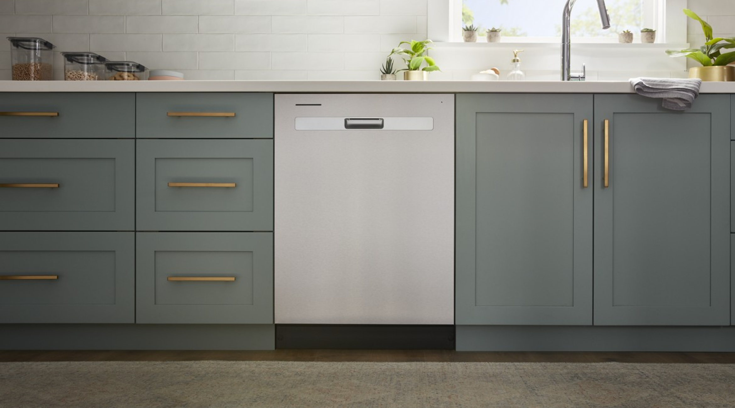 A Whirlpool® Starter Dishwasher in a kitchen with green cabinetry