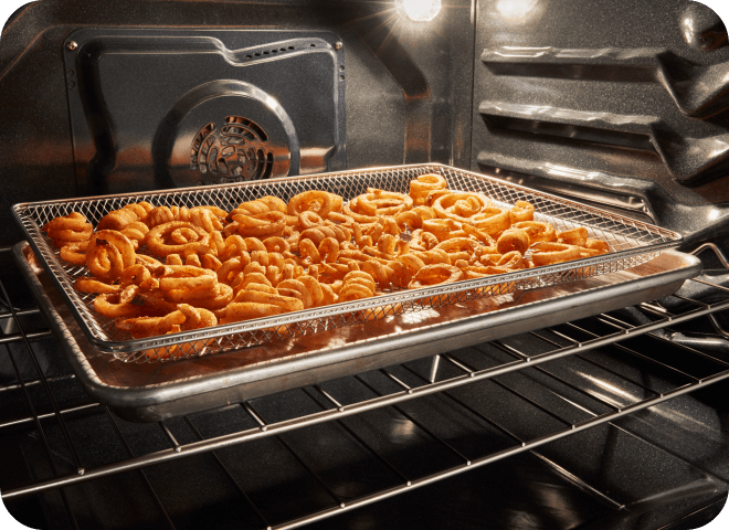 Curly fries being air fried in a Whirlpool® Range Oven