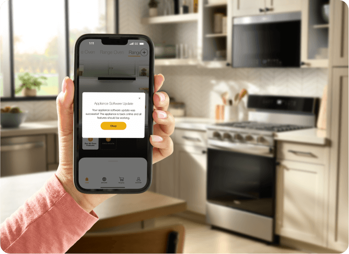 A hand holding the Whirlpool® App showing an update for the Whirlpool® Smart Range