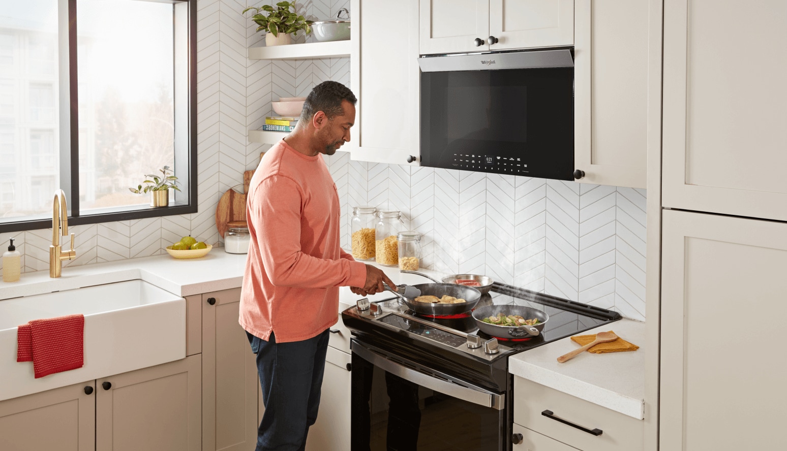A person cooking food below a Whirlpool® Flush Over-The-Range Microwave.