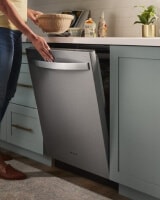 Person closing a top control dishwasher