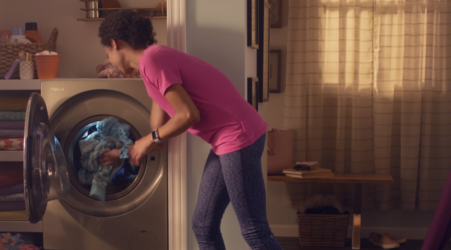 Person removing clothes from a dryer Person removing clothes from a dryer