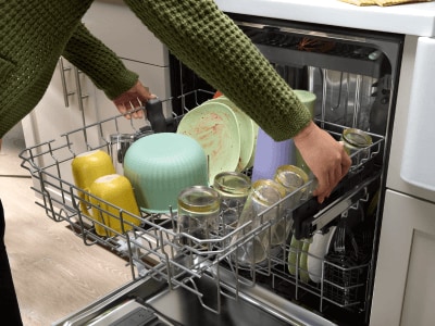 Person adjusting a dishwasher rack