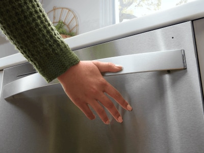 Person closing a dishwasher