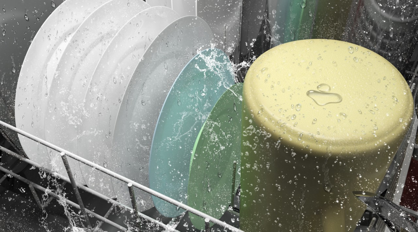 Dishes inside a dishwasher in the middle of a wash cycle Dishes inside a dishwasher in the middle of a wash cycle