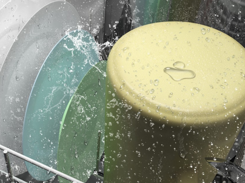 Dishes inside a dishwasher in the middle of a wash cycle Dishes inside a dishwasher in the middle of a wash cycle