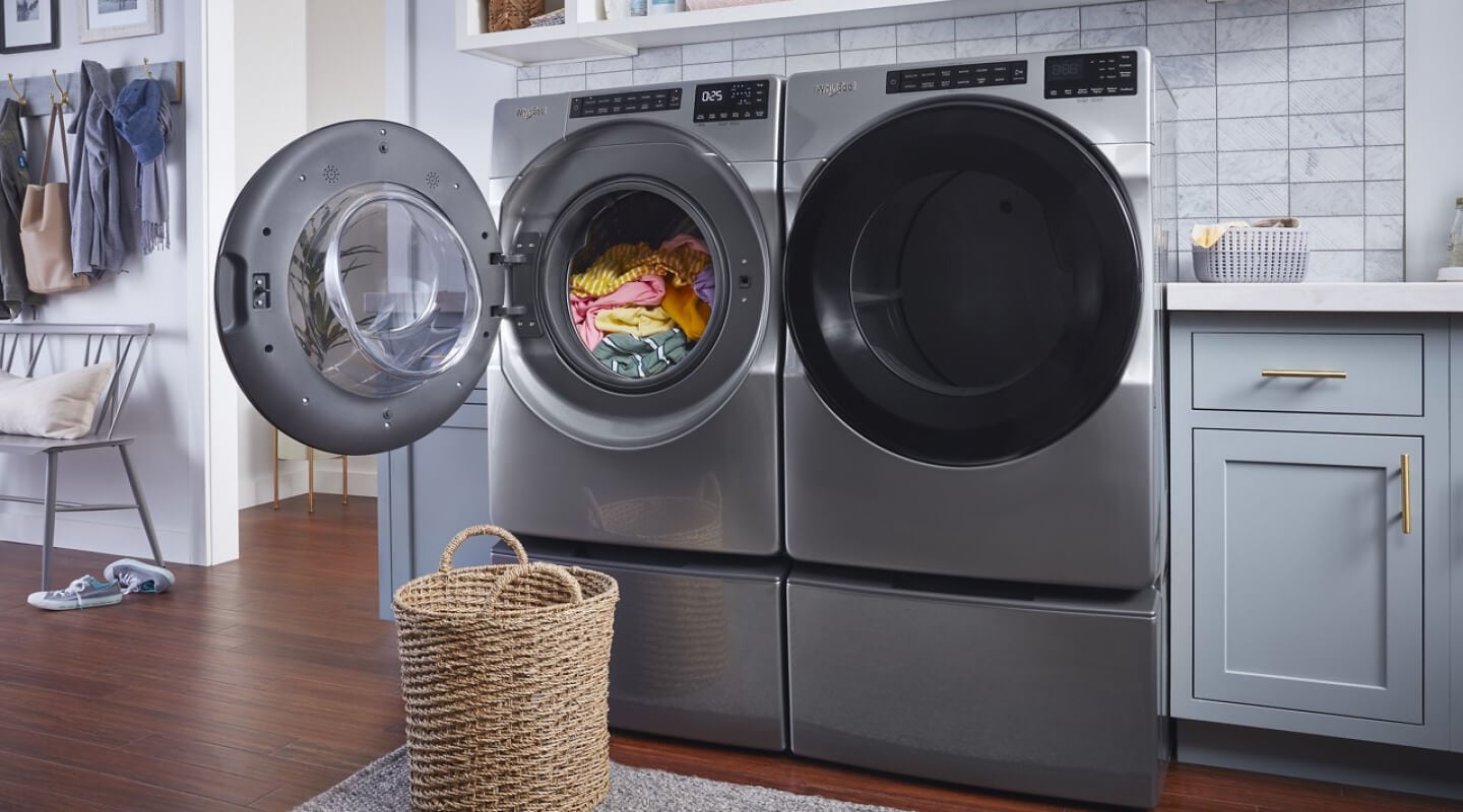 Whirlpool® Front Load Washer and Dryer pair on pedestals with the washer door open
