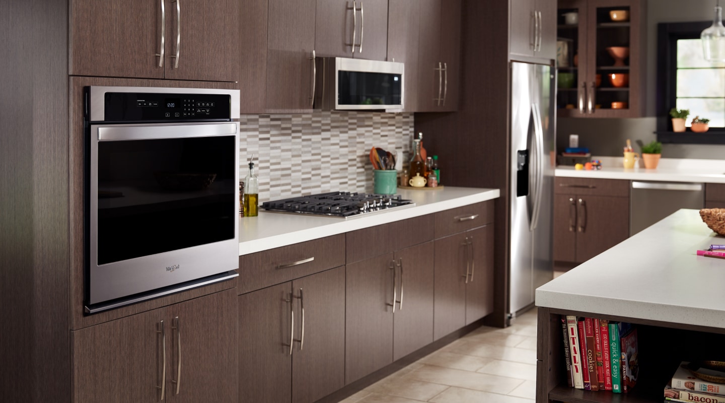 Stainless steel built-in wall oven in a kitchen with dark wood cabinets Stainless steel built-in wall oven in a kitchen with dark wood cabinets