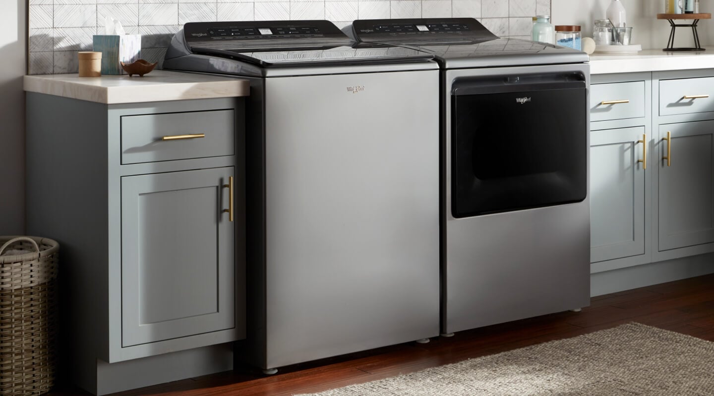 A gray metallic Whirlpool® washer and dryer in a modern laundry room