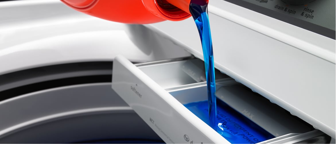 Liquid laundry detergent pouring into washer Liquid laundry detergent pouring into washer