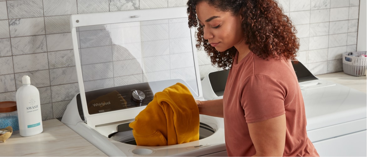 Woman pulling laundry out of Whirlpool® Washer Woman pulling laundry out of Whirlpool® Washer