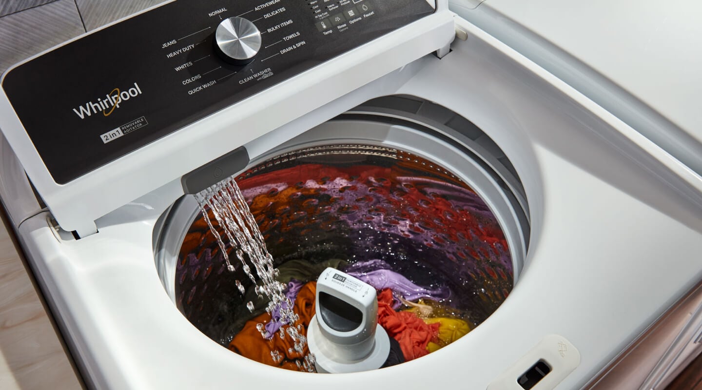 A closeup of a Whirlpool® top load washer running a load of clothes