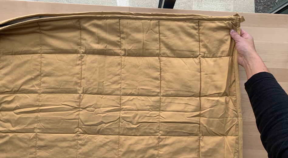 Person folding a weighted blanket Person folding a weighted blanket
