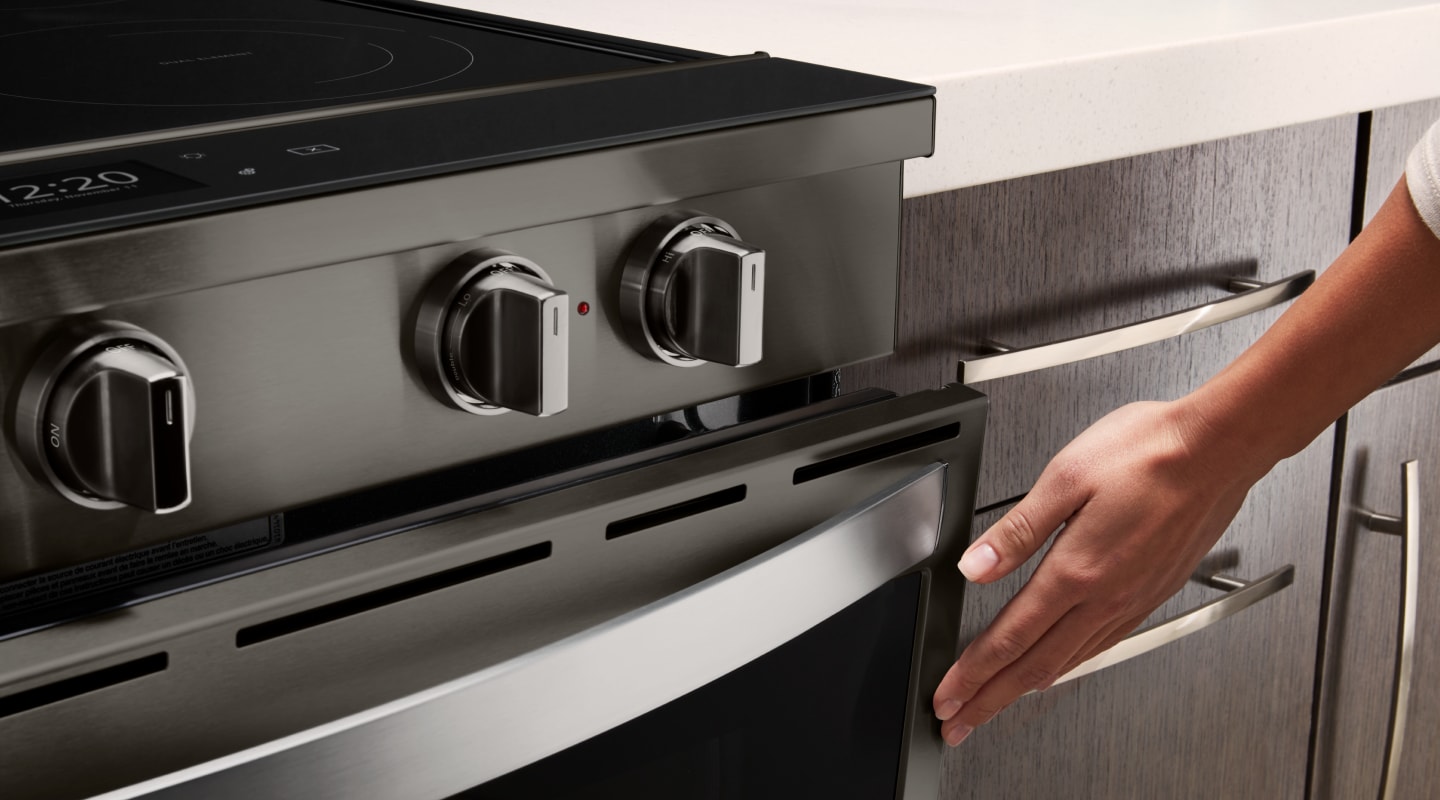 Person touching door of oven Person touching door of oven