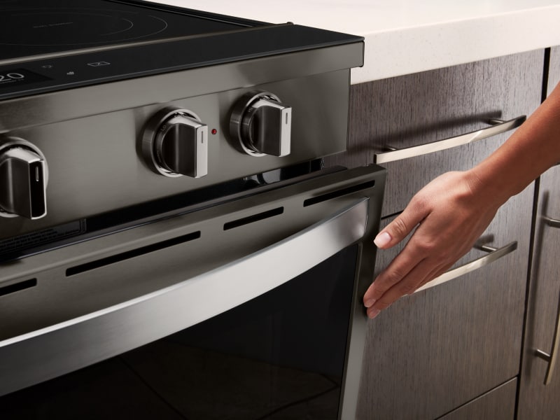 Person touching door of oven Person touching door of oven