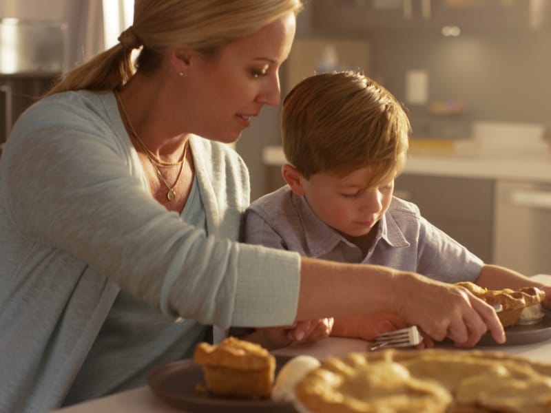 Adult and child serving pie at a kitchen island Adult and child serving pie at a kitchen island
