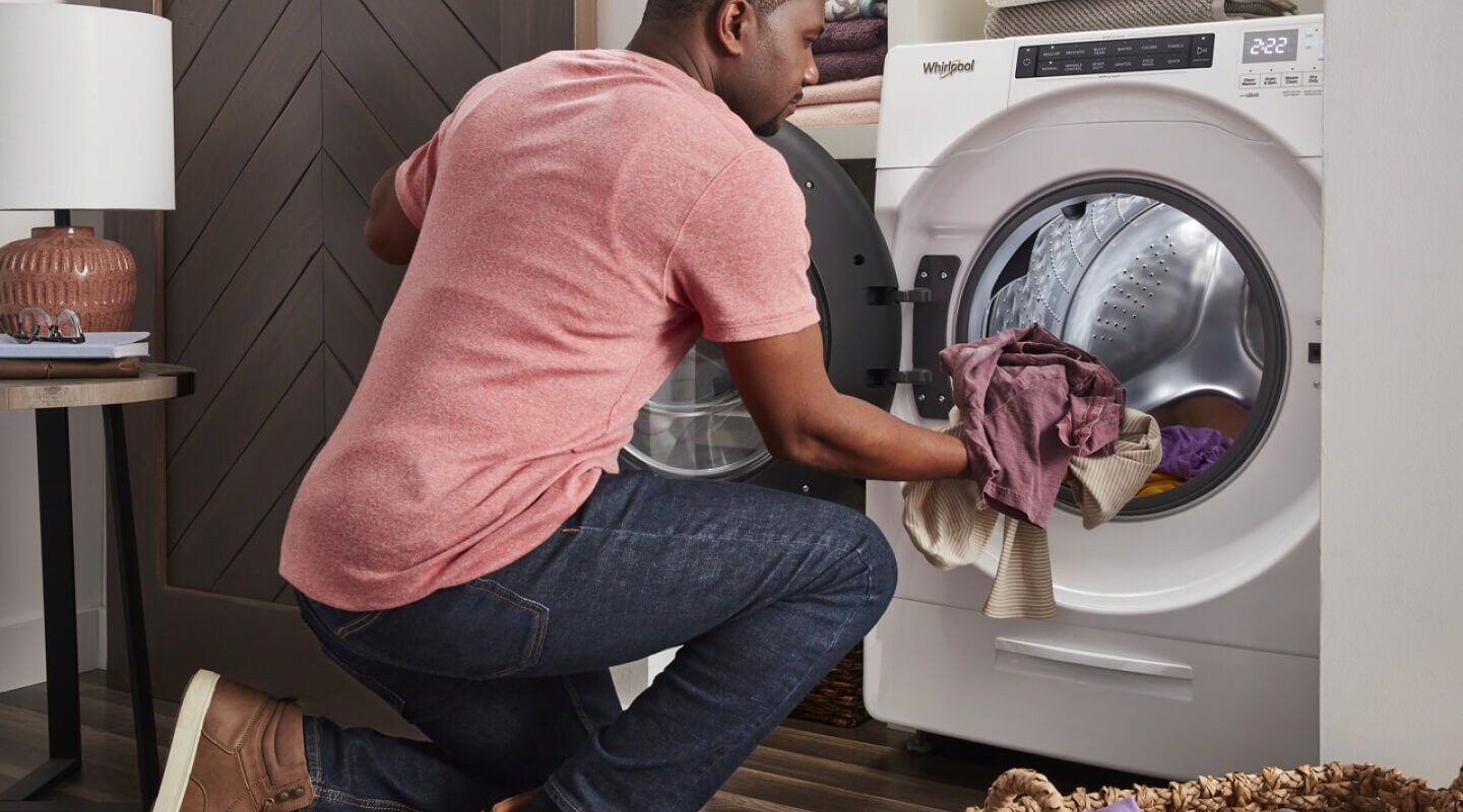 Person loading laundry in a Whirlpool® Dryer Person loading laundry in a Whirlpool® Dryer