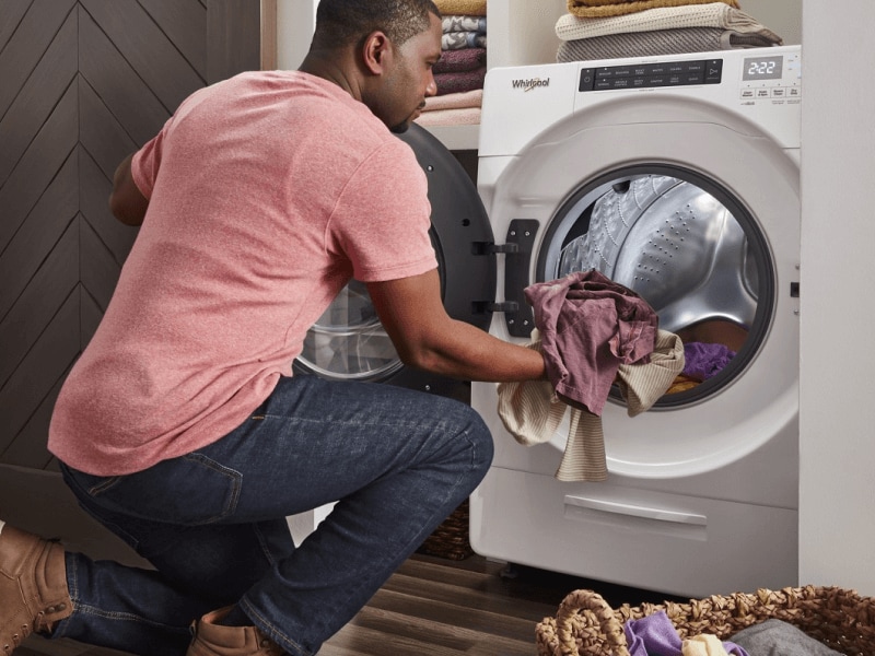 Person loading laundry in a Whirlpool® Dryer Person loading laundry in a Whirlpool® Dryer