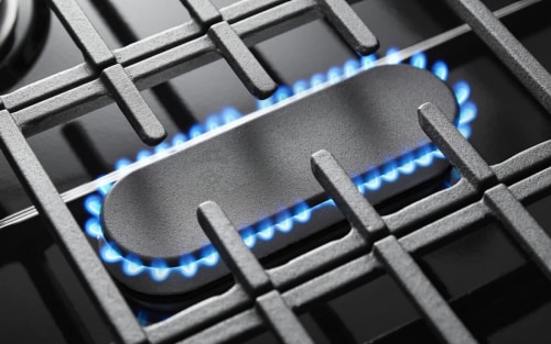 The lit middle oval burner on a Whirlpool brand gas range