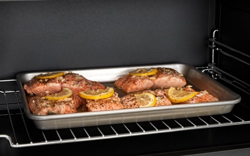 Salmon filets on a sheet pan inside a microwave