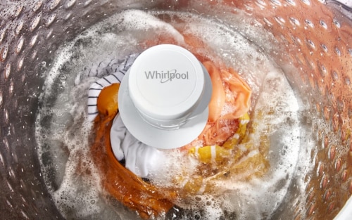 Clothing in a top load washing machine with an agitator going through an active wash cycle