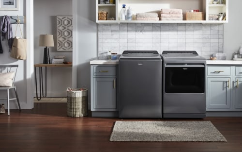 A grey Whirlpool® Top Load Washer and Dryer set