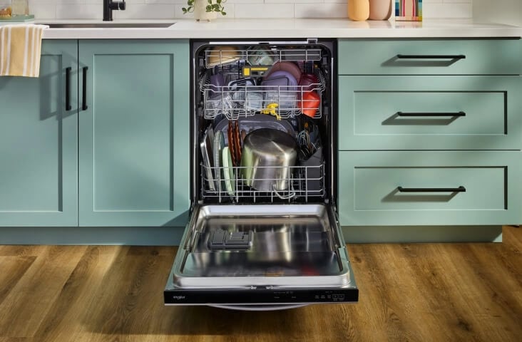 An opened, fully loaded Whirlpool® Dishwasher with a third rack